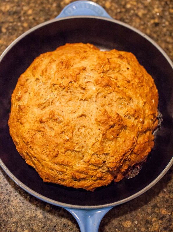 loaf of no knead whole wheat bread sitting in skillet 