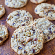 Freshly baked chocolate chip cookies with nuts cooling on a wooden board.