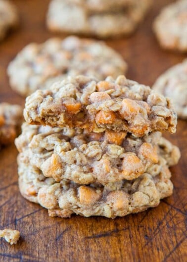 A stack of oatmeal cookies with butterscotch chips on a wooden surface.