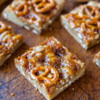 Homemade caramel pretzel bars on a wooden surface.