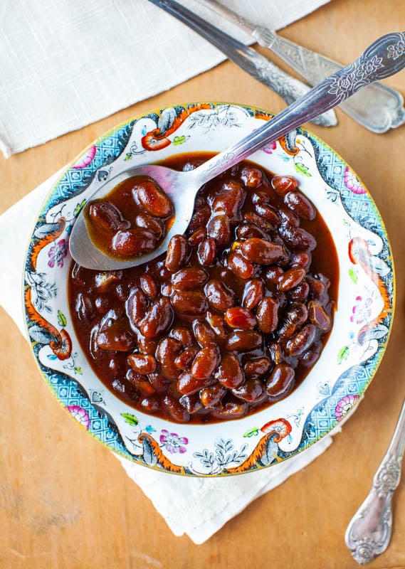 small bowl of slow cooker baked beans with spoon on top