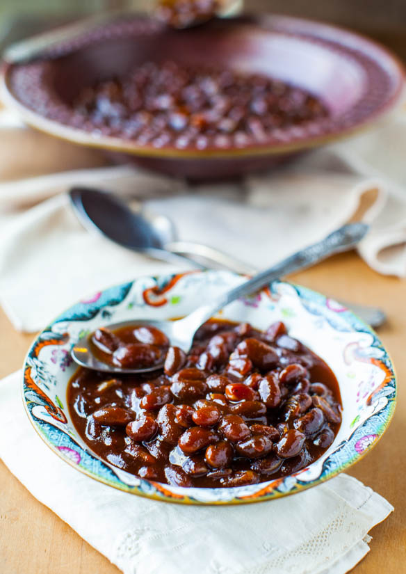 small dish of baked beans from scratch with spoon resting on top
