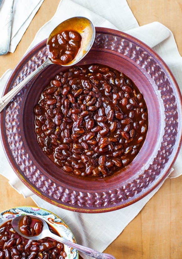 large bowl of slow cooker baked beans with spoon resting on the side