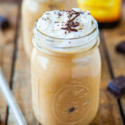 Iced coffee with whipped cream and chocolate shavings served in a mason jar.