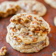 Stack of homemade cookies with visible chunks on a wooden surface.