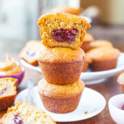 Three cornbread muffins stacked with a dollop of jam visible in the center of the top muffin.