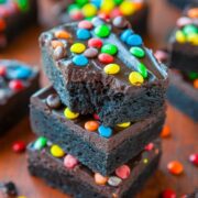 A stack of chocolate brownies topped with colorful candy-coated chocolates.
