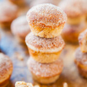Stack of sugar-coated doughnut holes with more scattered in the background.