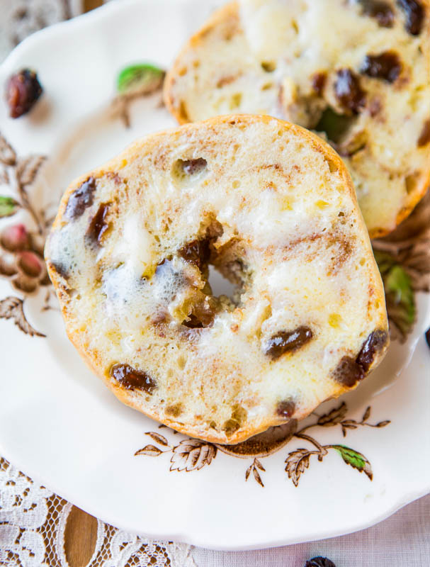 closeup of cinnamon raisin bagel topped with butter on floral plate