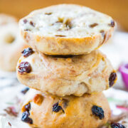 A stack of three bagels with raisins on a plate.
