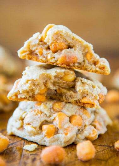 A stack of butterscotch chip cookies on a wooden surface.