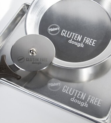 Gluten-free dough preparation set with rolling pin and cutter on a metal surface.