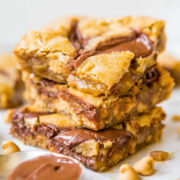 Stack of peanut butter chocolate chip blondies on a white surface.