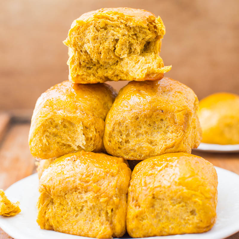 A stack of golden-brown pumpkin biscuits on a white plate.