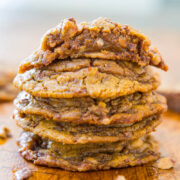 A stack of freshly-baked cookies on a wooden surface.