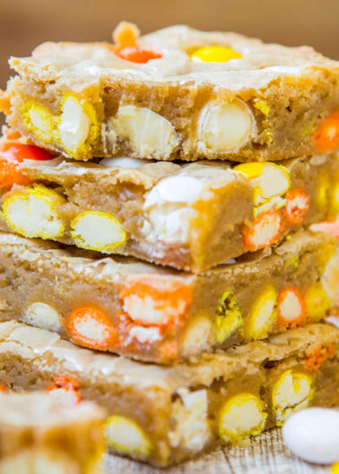 A stack of candy-filled blondies on a wooden surface.