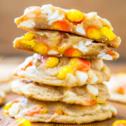 A stack of candy corn cookies on a wooden surface.