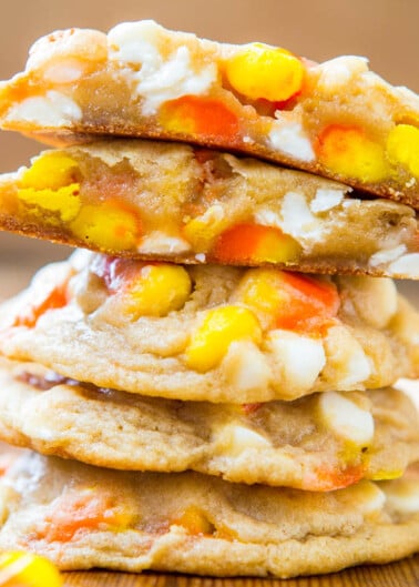A stack of candy corn cookies on a wooden surface.