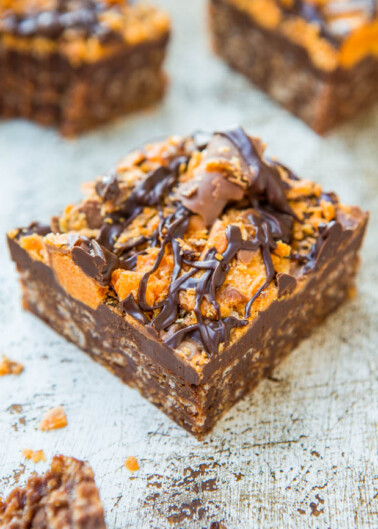 Chocolate fudge topped with caramel, nuts, and a drizzle of chocolate.