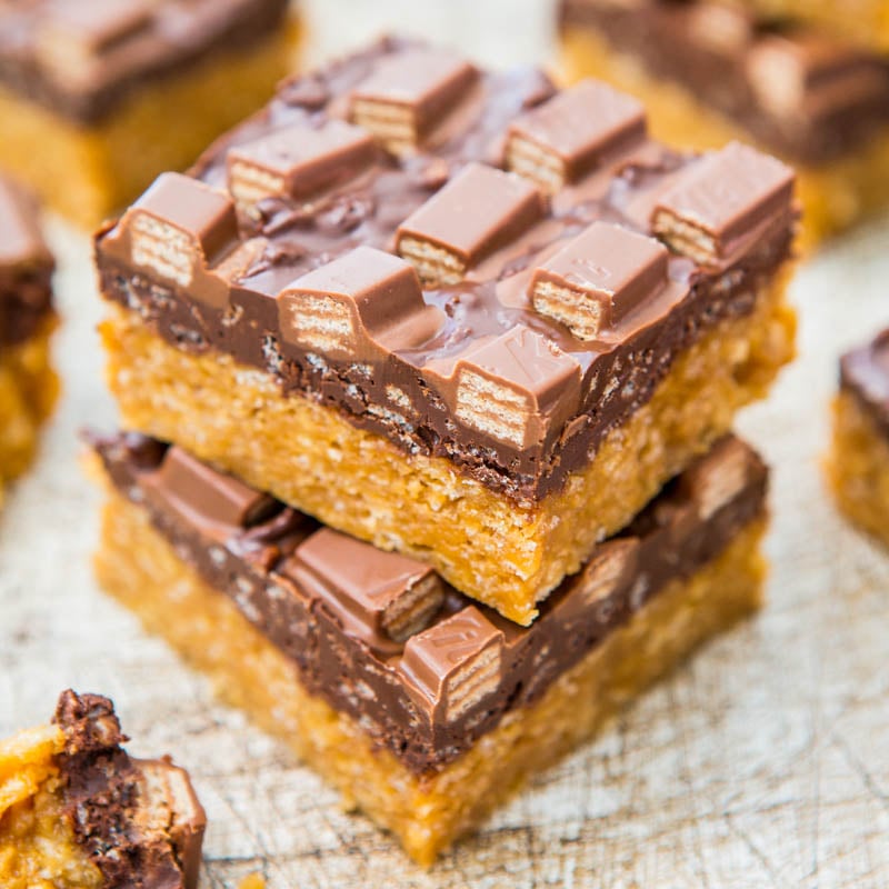 Stack of chocolate caramel slices on a textured surface.