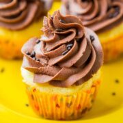 Vanilla cupcakes with chocolate frosting on a yellow plate.