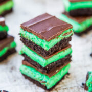 A stack of mint chocolate layered dessert bars on a surface.