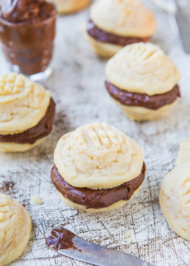 vanilla sandwich cookies with Nutella filling next to a glass of Nutella 