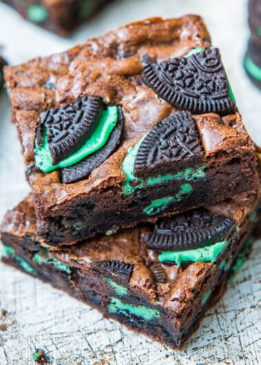 A stack of brownies with pieces of green-filled chocolate sandwich cookies embedded.
