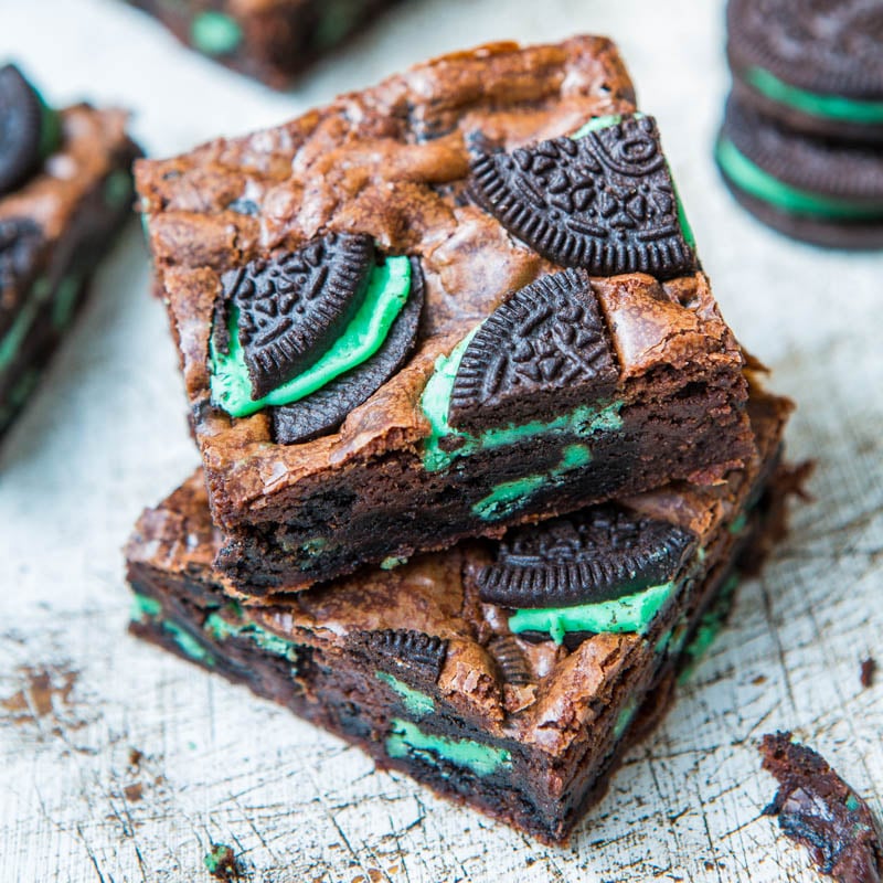 A stack of brownies with pieces of green-filled chocolate sandwich cookies embedded.