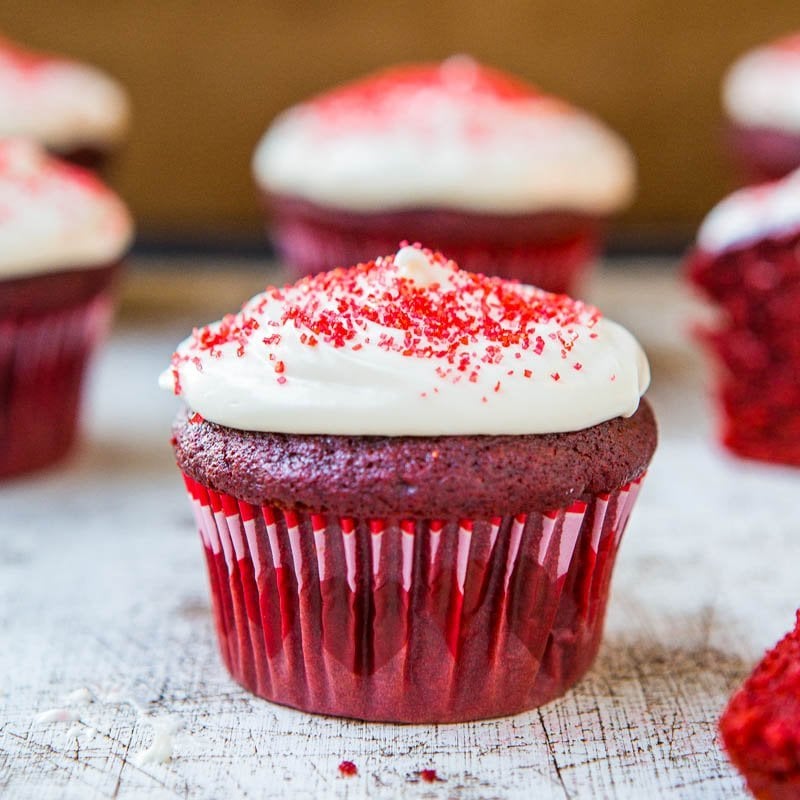Red velvet cupcakes with cream cheese frosting and red sprinkles.
