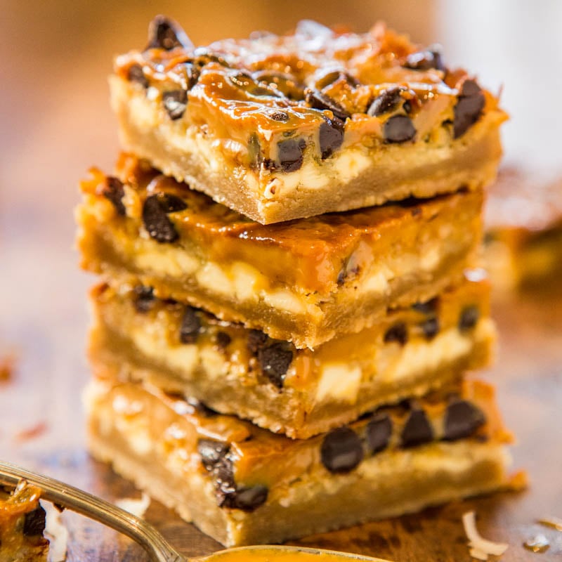 A stack of caramel and chocolate chip squares on a wooden surface.