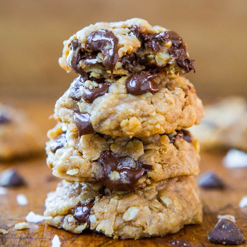 A stack of three chocolate chip oatmeal cookies with visible gooey chocolate chunks.