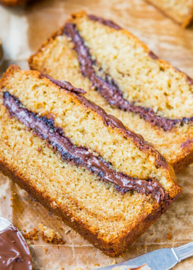 Slices of banana bread with a chocolate spread filling on parchment paper.