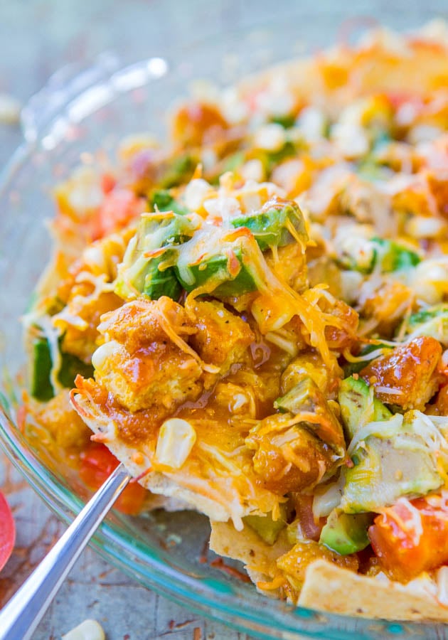 Loaded BBQ Chicken Nachos — Loaded with avocado chunks, juicy tomatoes and corn, and bbq sauce-smothered chicken! Perfect for parties, tailgating, game days, and more! 