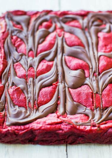 A red velvet brownie with chocolate swirls and heart-shaped decorations.