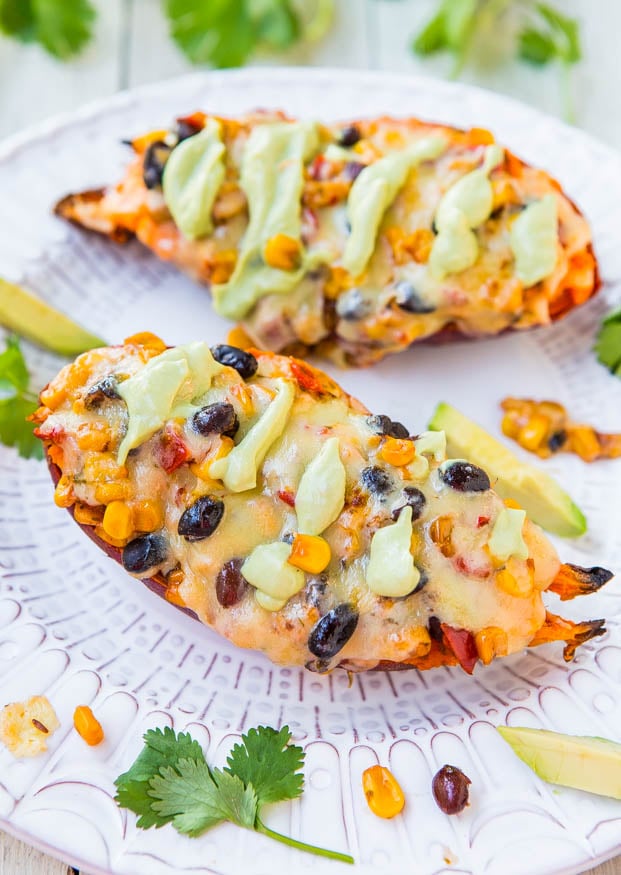 Two Cheese, Black Bean, and Corn-Stuffed Sweet Potatoes with Avocado Crema on plate