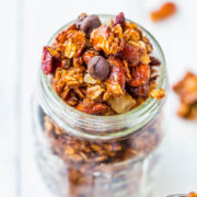 A jar filled with homemade granola containing oats, nuts, and chocolate chips.