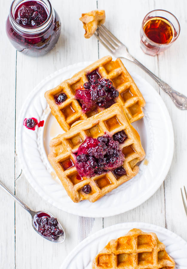 overhead view of two buttermilk waffles topped with berry preserves on a white plate