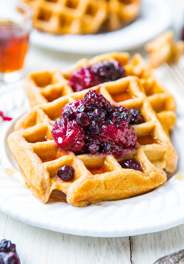 two buttermilk waffles topped with berry preserves on a white plate