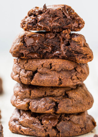 A stack of gooey chocolate cookies on a light surface.