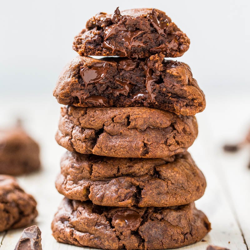 A stack of gooey chocolate cookies on a light surface.