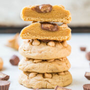A stack of peanut butter cookies with chocolate pieces on a white surface.