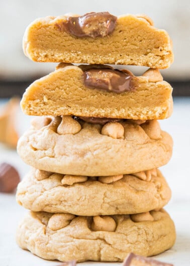 A stack of peanut butter cookies with chocolate pieces on a white surface.