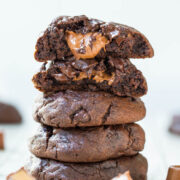 A stack of gooey chocolate cookies with melting chocolate chunks.