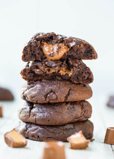 A stack of gooey chocolate cookies with melting chocolate chunks.