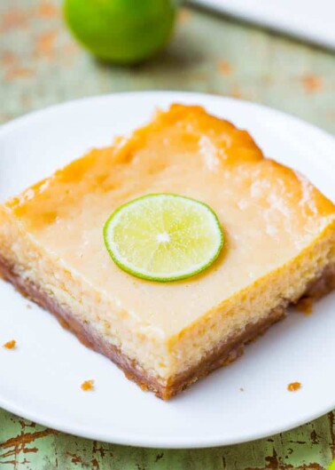 A slice of key lime pie with a lime garnish on a white plate.