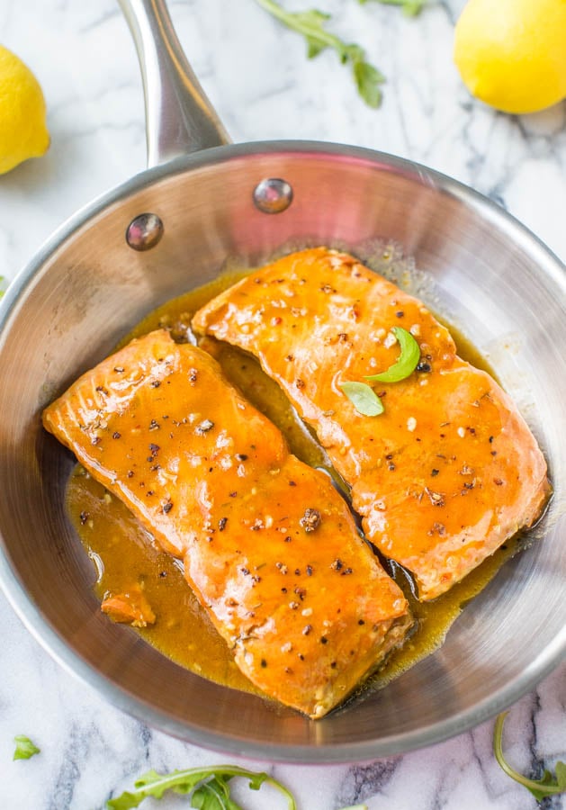 overhead view of two bbq glazed salmon fillets in a metal skillet 