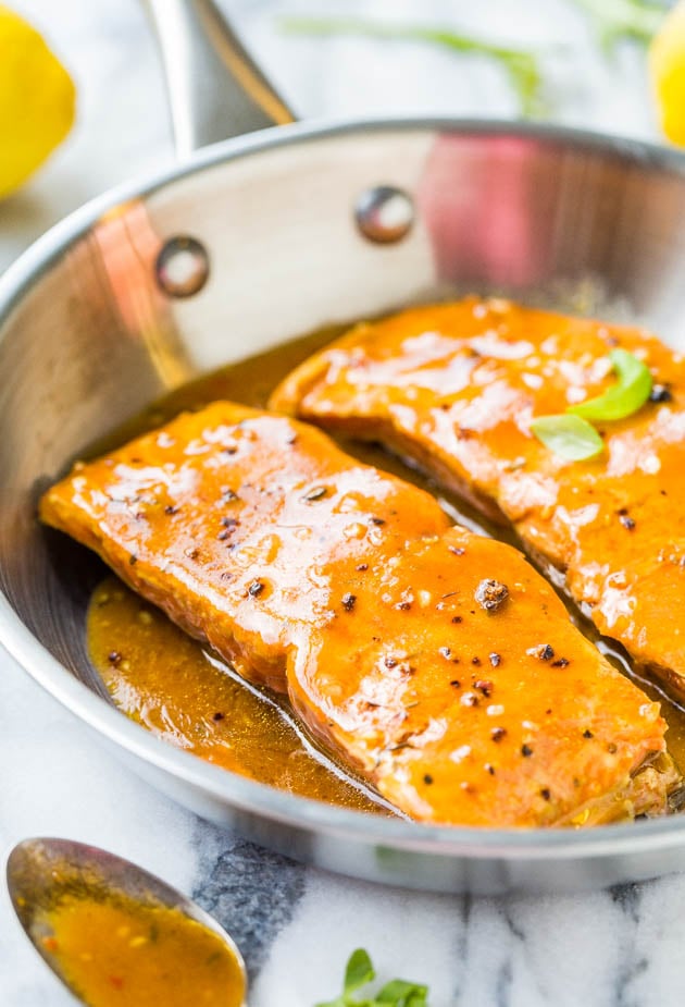 side view of two bbq salmon fillets in a metal skillet 