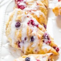 Berry scones with a white glaze on a rectangular plate.