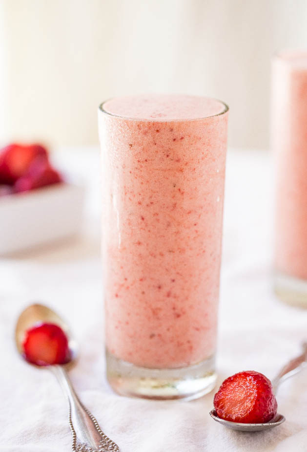glass of Banana Strawberry Pineapple Smoothie with two spoons
